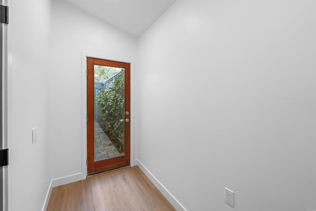 entryway with lofted ceiling, baseboards, and light wood finished floors