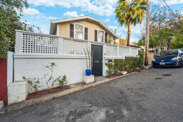 view of front of house featuring stucco siding and fence