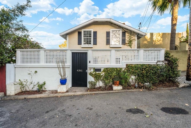 view of front of property with stucco siding and fence