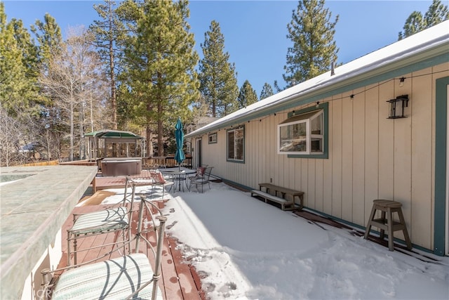 exterior space featuring outdoor dining area and a hot tub