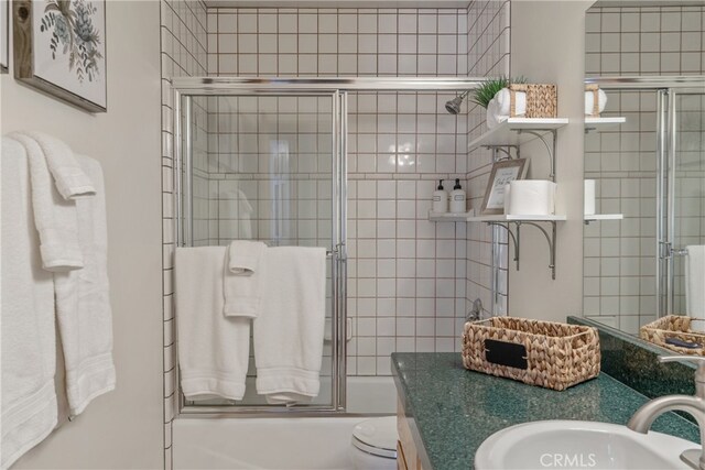 bathroom featuring shower / bath combination with glass door, vanity, and toilet