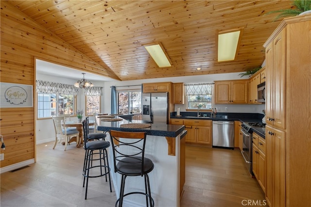 kitchen with a center island, appliances with stainless steel finishes, a breakfast bar, and a wealth of natural light