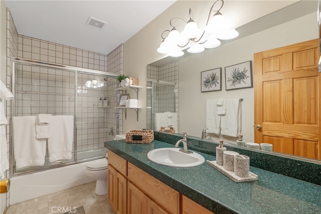 full bathroom with visible vents, a chandelier, toilet, combined bath / shower with glass door, and vanity