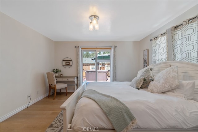 bedroom featuring baseboards, light wood-style floors, and access to outside