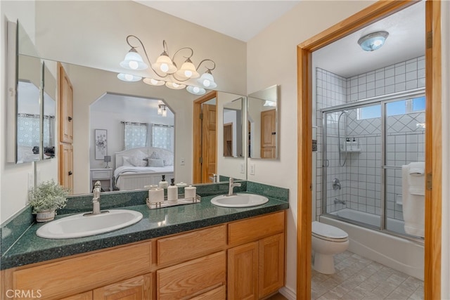 ensuite bathroom featuring double vanity, combined bath / shower with glass door, ensuite bathroom, and a sink