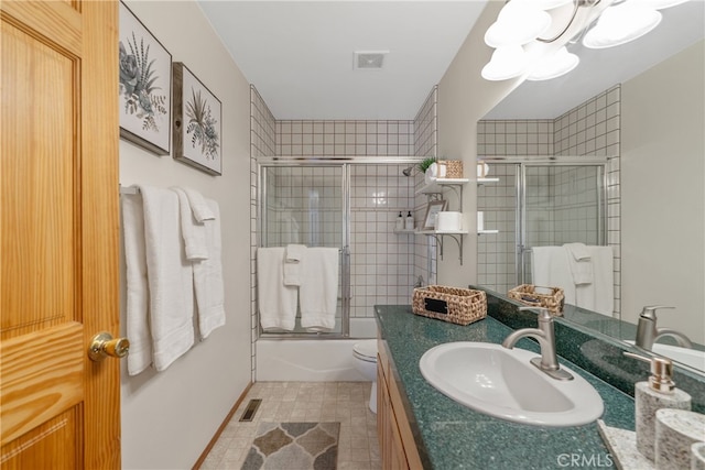 full bathroom featuring vanity, enclosed tub / shower combo, visible vents, and a chandelier