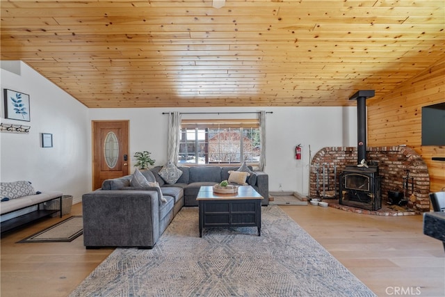 living room featuring wood ceiling, a wood stove, lofted ceiling, and wood finished floors