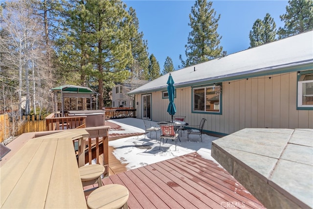 wooden deck with outdoor dining space and a patio