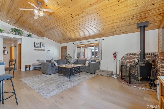 living room featuring wood finished floors, a ceiling fan, high vaulted ceiling, a wood stove, and wood ceiling