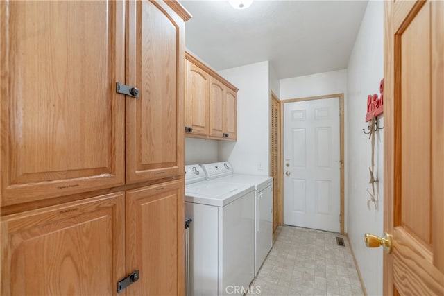 washroom featuring washing machine and dryer, cabinet space, visible vents, and light floors