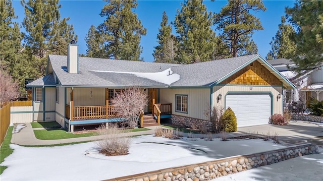 ranch-style house with fence, a porch, a chimney, driveway, and an attached garage