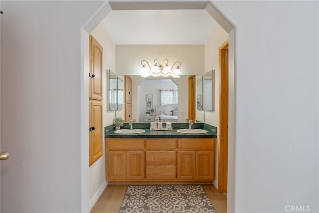 full bathroom with a sink, wood finished floors, and double vanity