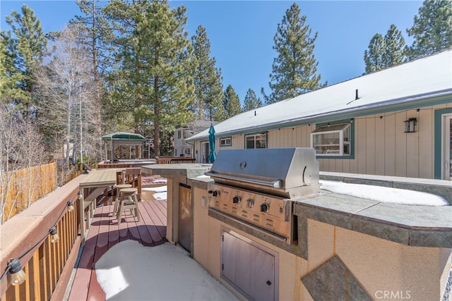 view of patio with area for grilling and a wooden deck