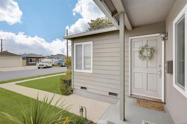 property entrance with crawl space and a lawn