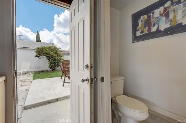 bathroom with tile patterned floors, toilet, and baseboards