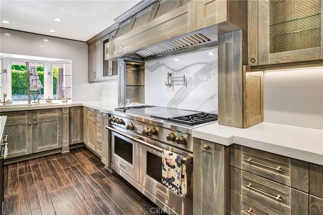 5441 Calvin Ave, Tarzana, CA 91356 - kitchen featuring glass insert cabinets, ventilation hood, dark wood-style flooring, light countertops, and range with two ovens