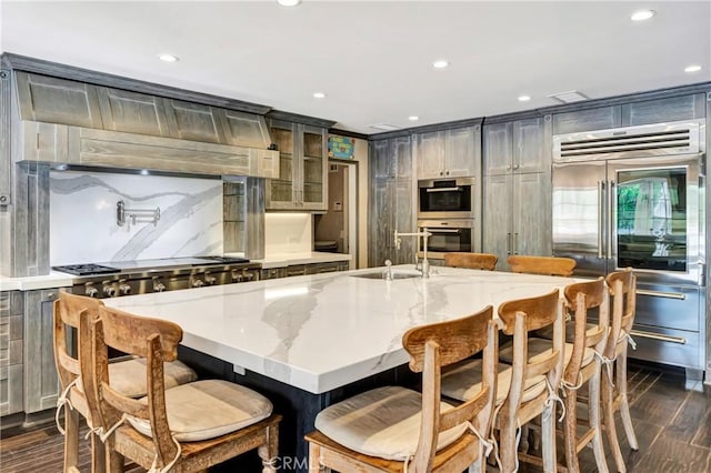 5441 Calvin Ave, Tarzana, CA 91356 - kitchen featuring glass insert cabinets, appliances with stainless steel finishes, light stone counters, a sink, and dark wood-style floors