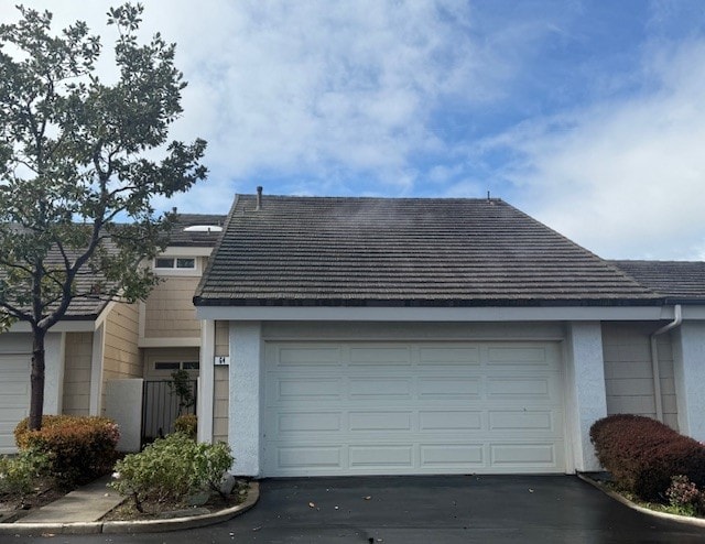 view of front of house featuring aphalt driveway, a garage, and stucco siding