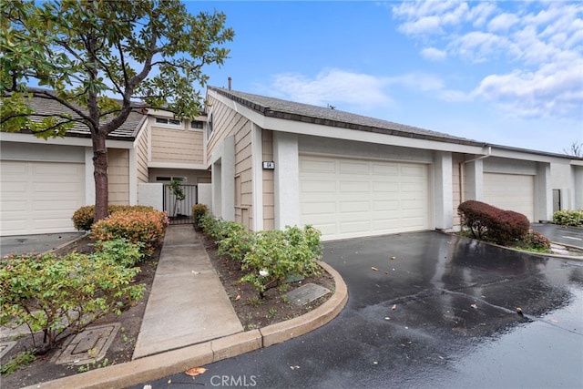 view of front of home with a gate, a garage, and stucco siding