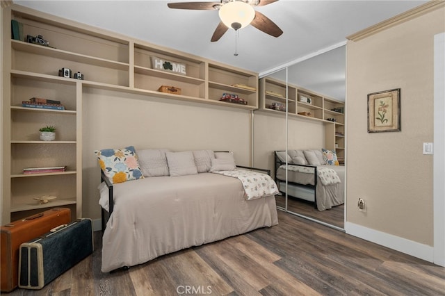 bedroom featuring a closet, ceiling fan, baseboards, and wood finished floors