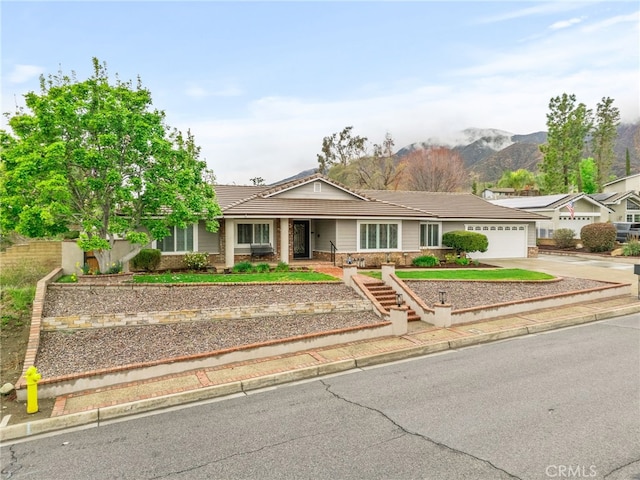 single story home with a tiled roof, an attached garage, and driveway