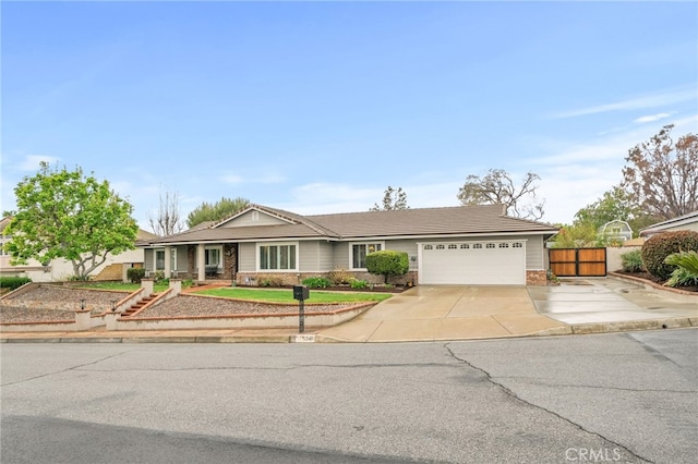 ranch-style house featuring a garage, driveway, and fence