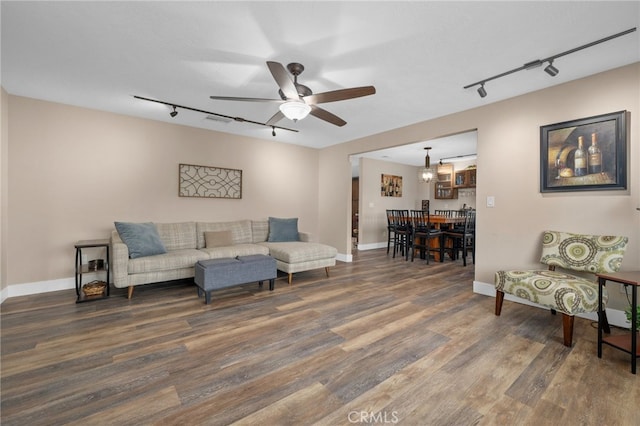 living area with visible vents, baseboards, ceiling fan, and wood finished floors