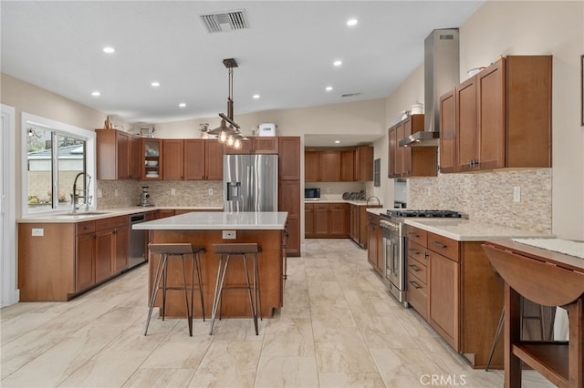 kitchen with visible vents, brown cabinets, a sink, a center island, and stainless steel appliances