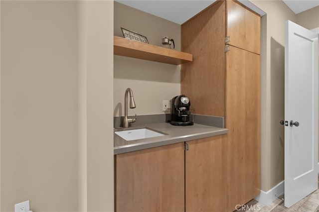 kitchen featuring open shelves, light countertops, and a sink