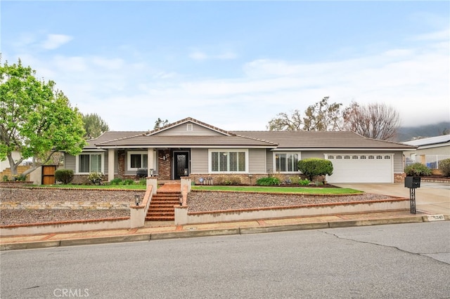 ranch-style house featuring brick siding, driveway, an attached garage, and a tiled roof