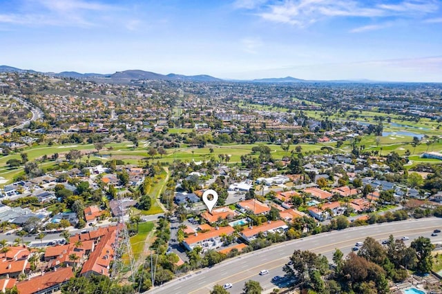 drone / aerial view featuring golf course view, a residential view, and a water and mountain view