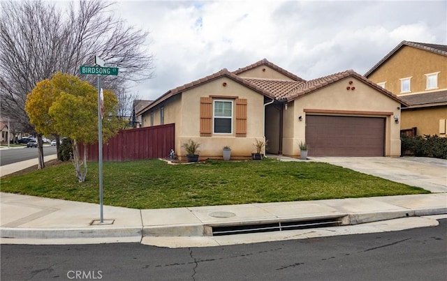 mediterranean / spanish home featuring a front yard, driveway, an attached garage, stucco siding, and a tiled roof