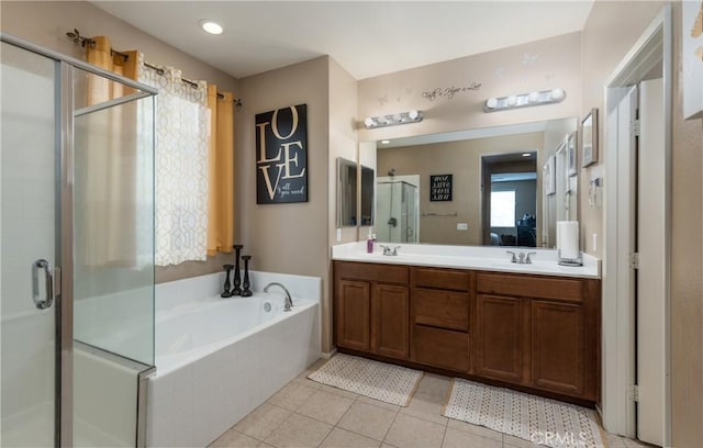 bathroom with double vanity, a sink, tile patterned flooring, a shower stall, and a garden tub