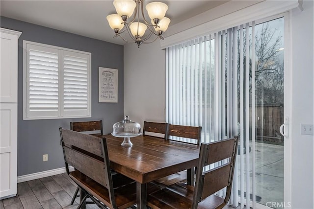 dining area with a notable chandelier, baseboards, and wood finished floors