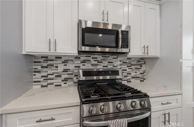 kitchen featuring white cabinets, tasteful backsplash, and stainless steel appliances