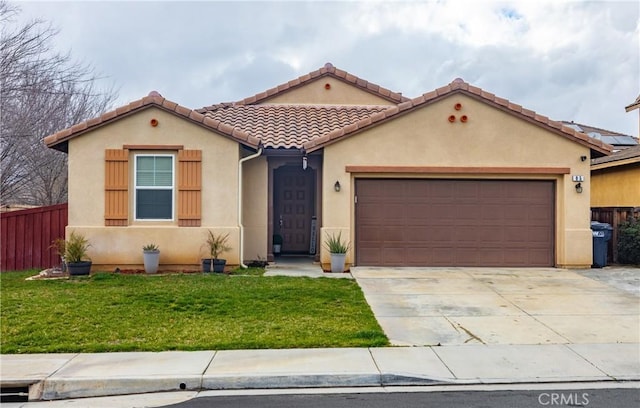 mediterranean / spanish home with fence, driveway, an attached garage, stucco siding, and a front lawn