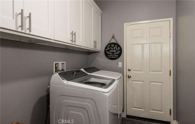 laundry room with washing machine and clothes dryer and cabinet space