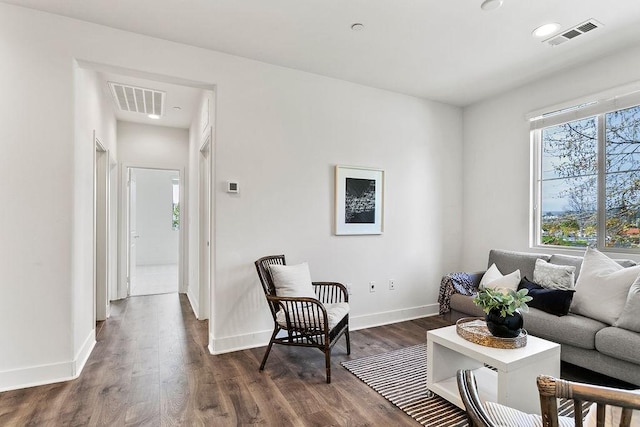 living room featuring visible vents, baseboards, and dark wood-style flooring