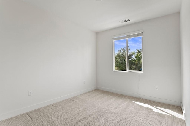 spare room with visible vents, baseboards, and carpet floors