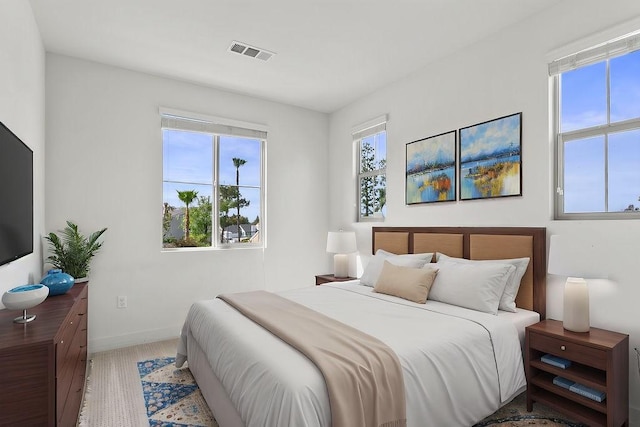 bedroom featuring light wood-style flooring, baseboards, and visible vents