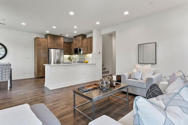 living area with recessed lighting, visible vents, dark wood-style floors, and stairs