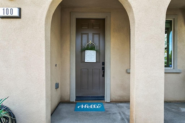 view of exterior entry featuring stucco siding