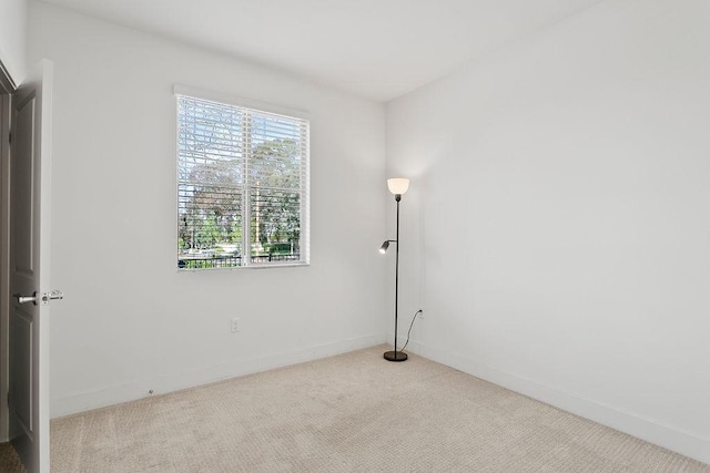 spare room featuring baseboards and carpet floors