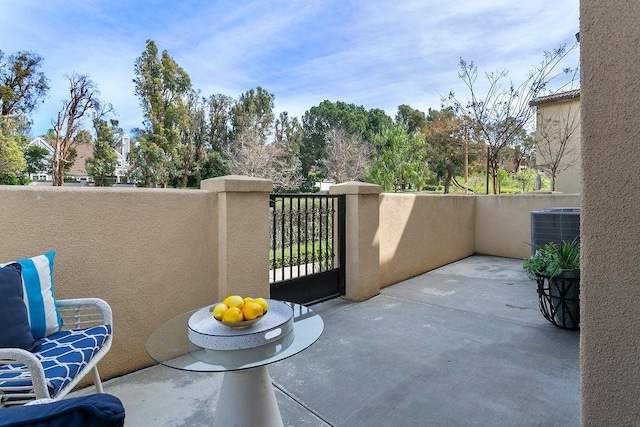 view of patio featuring central AC unit and a balcony