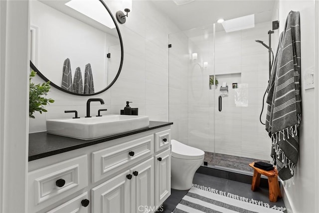 bathroom with vanity, a shower stall, tile walls, toilet, and tasteful backsplash