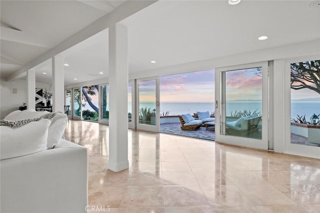 living area with recessed lighting, a water view, and marble finish floor