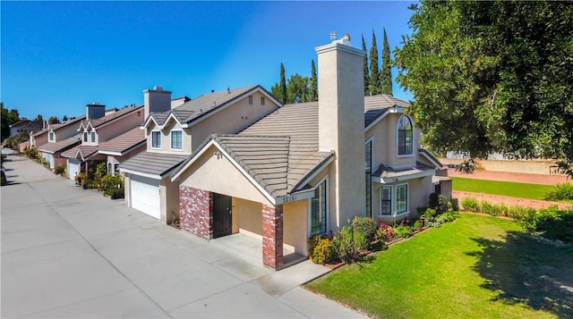 view of side of home with driveway, stucco siding, a chimney, a garage, and a lawn