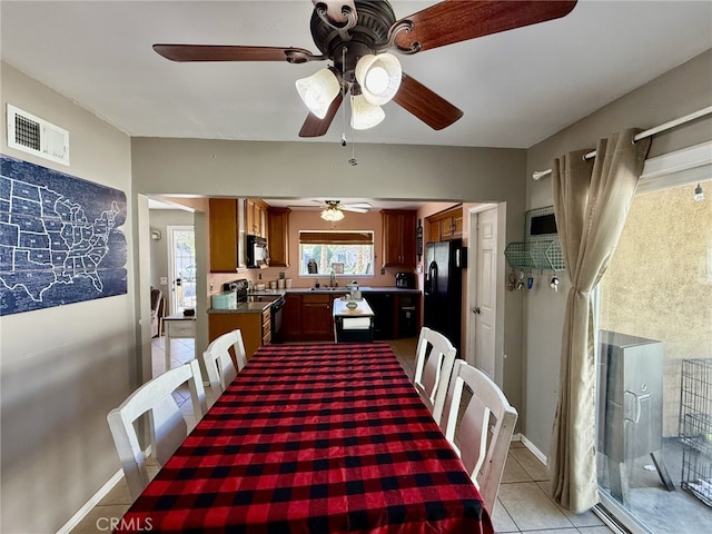 dining space featuring light tile patterned floors, visible vents, and baseboards