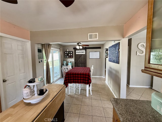 dining space with visible vents, baseboards, light tile patterned flooring, and a ceiling fan