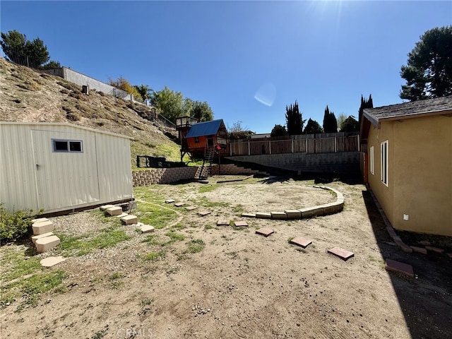 view of yard with an outbuilding, a storage shed, and fence